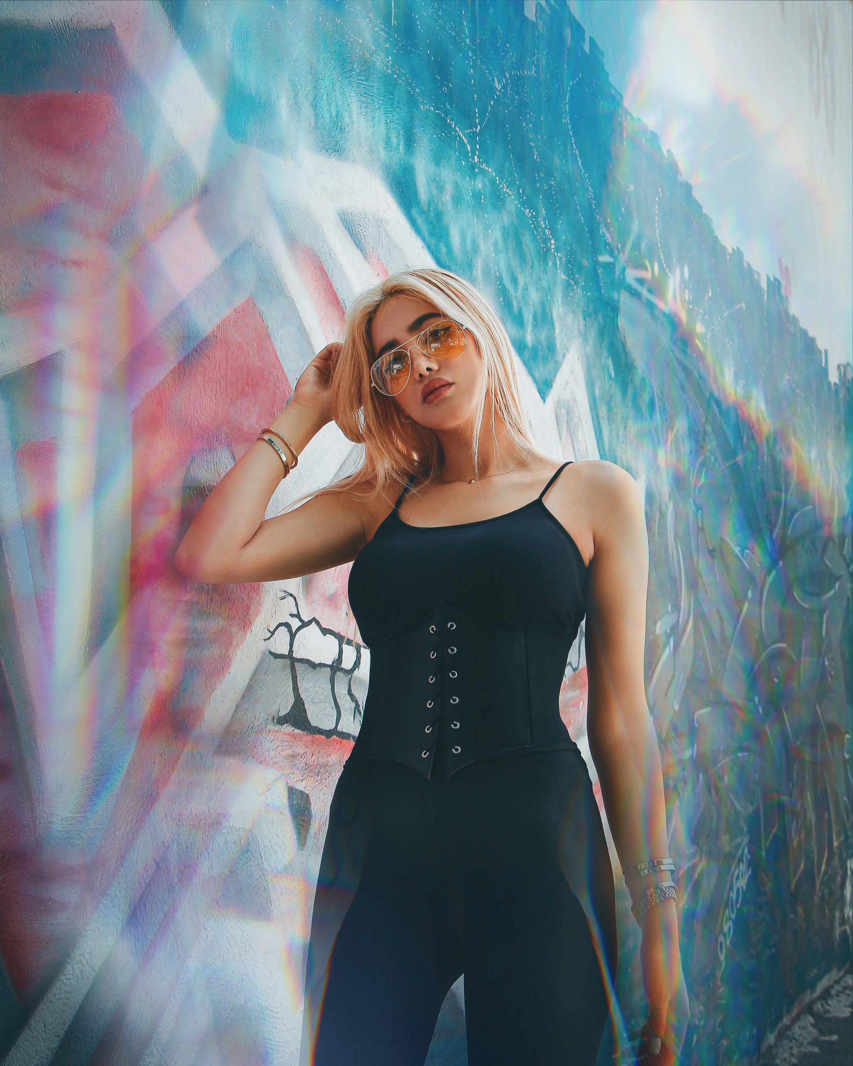 woman in black spaghetti strap dress standing in front of blue and white wall